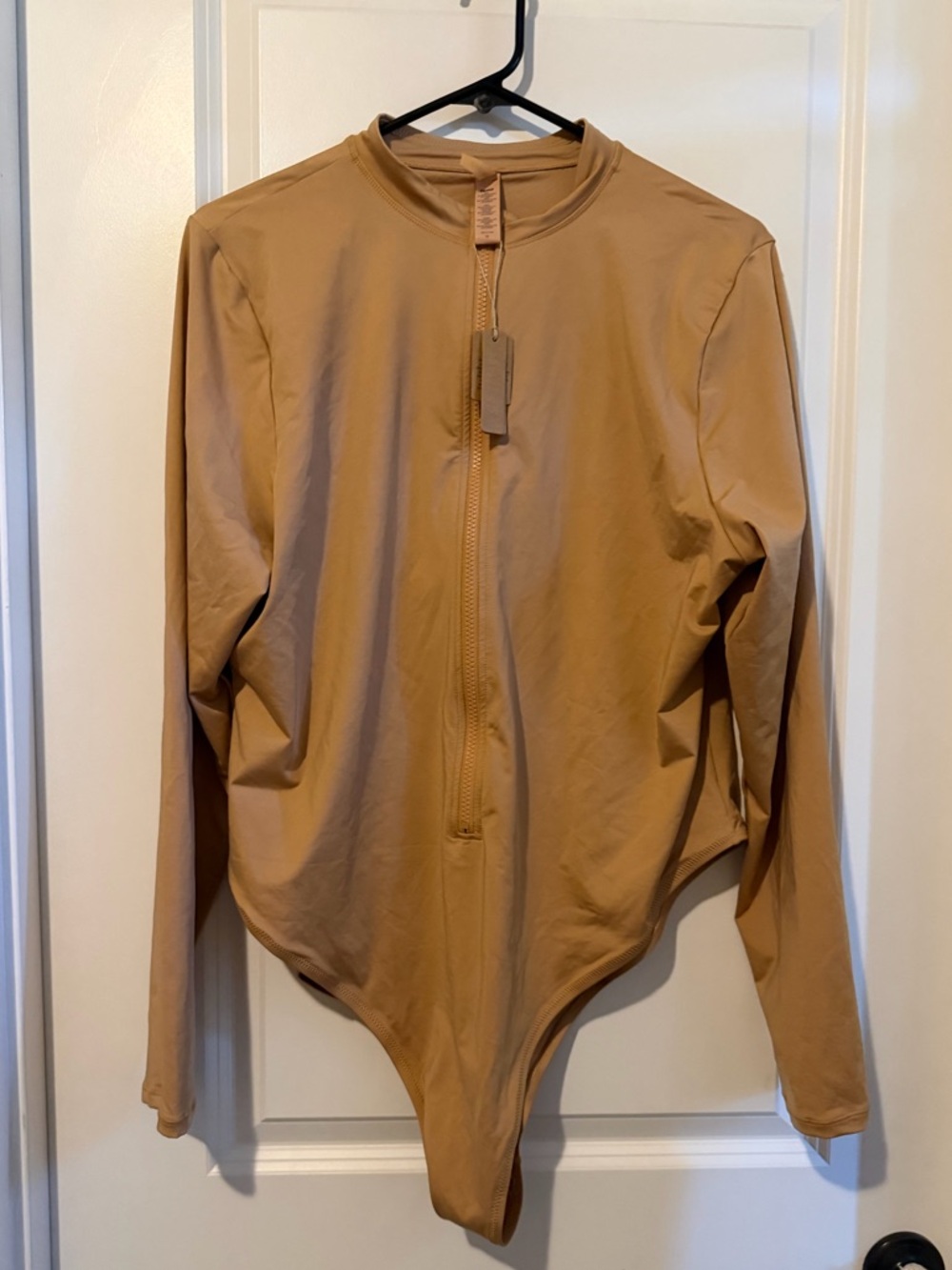 SKIMS Swim Zip Front Long Sleeve One Piece swimsuit.